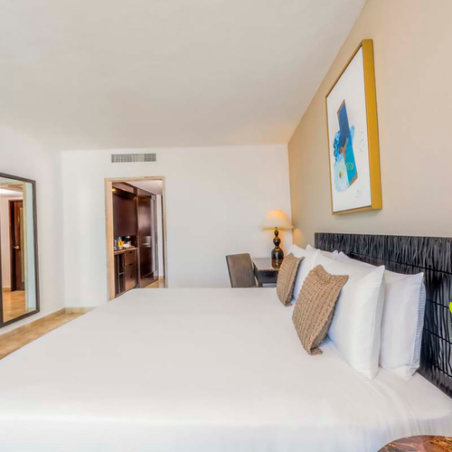 Luxurious hotel bedroom with a large bed, modern art, and a dresser DEMO 3.