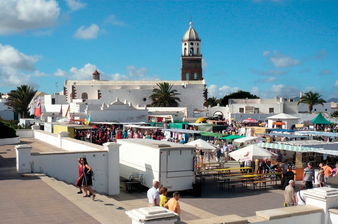 a busy market with a church in the background