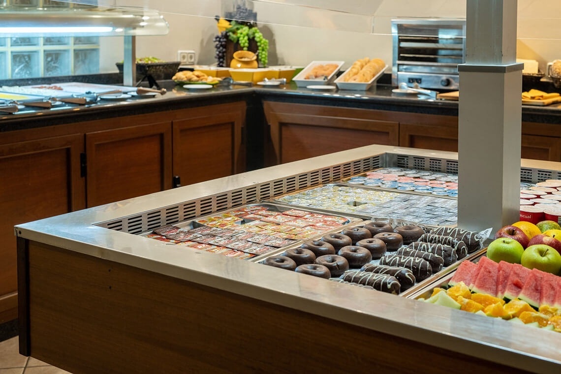 a buffet with a variety of food including donuts and fruit