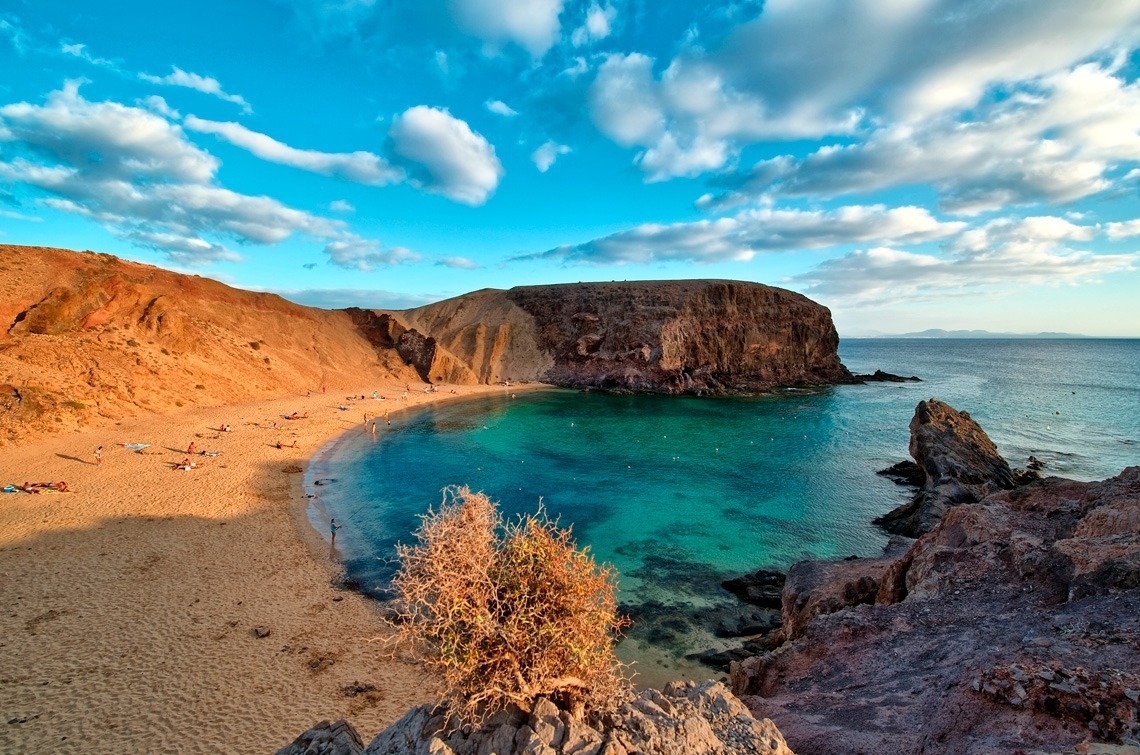a beach with a large rock in the middle of it