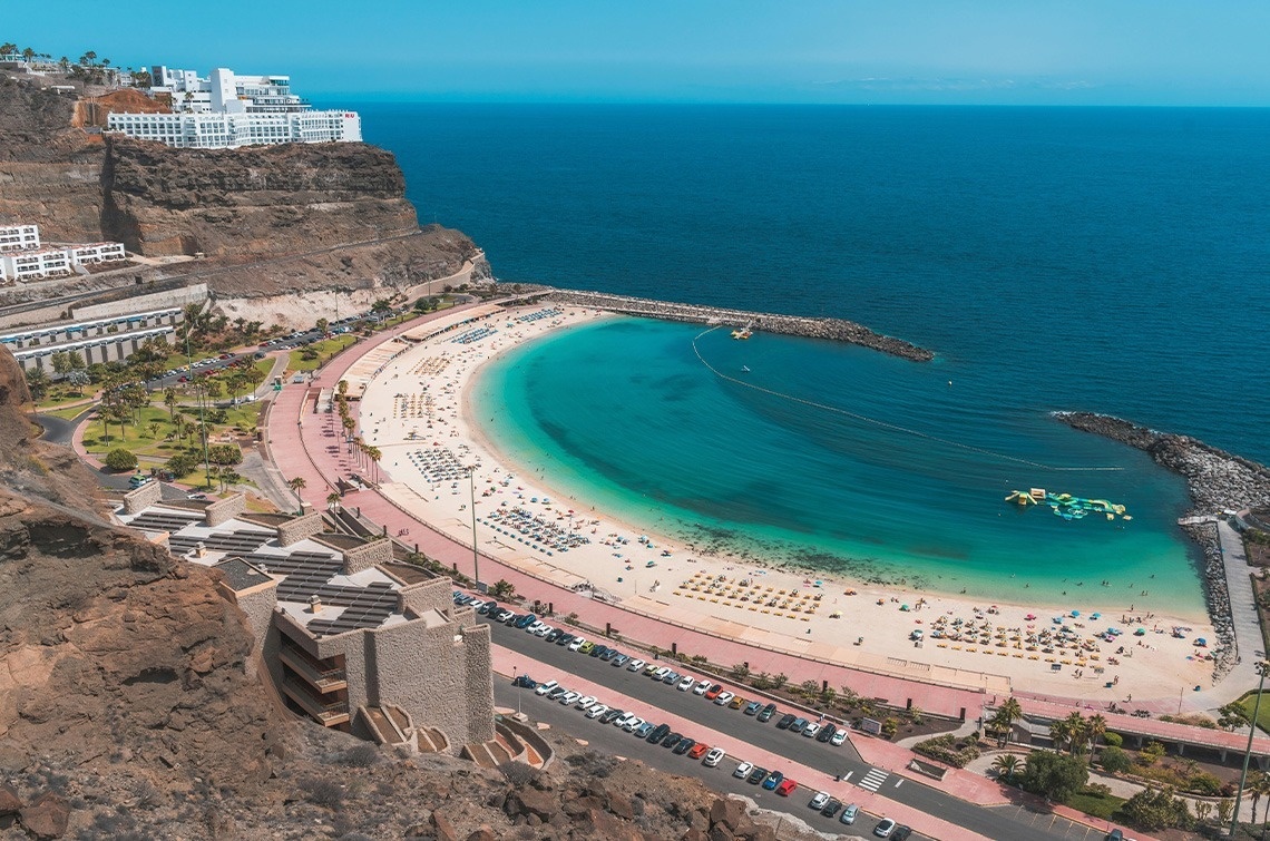 a large body of water with a beach in the foreground