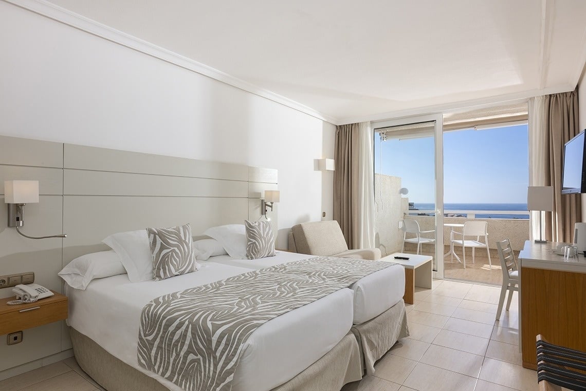 a hotel room with two beds and a balcony