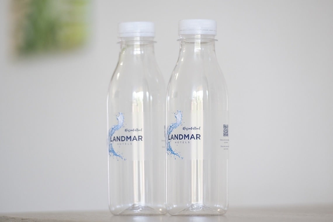 deux bouteilles d' eau landmar sont assises sur une table