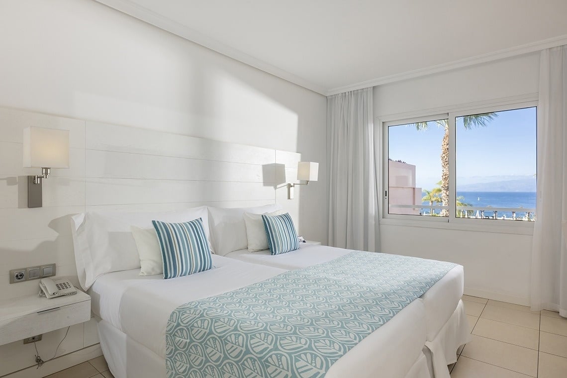 una habitación de hotel con dos camas y una ventana con vista al océano .