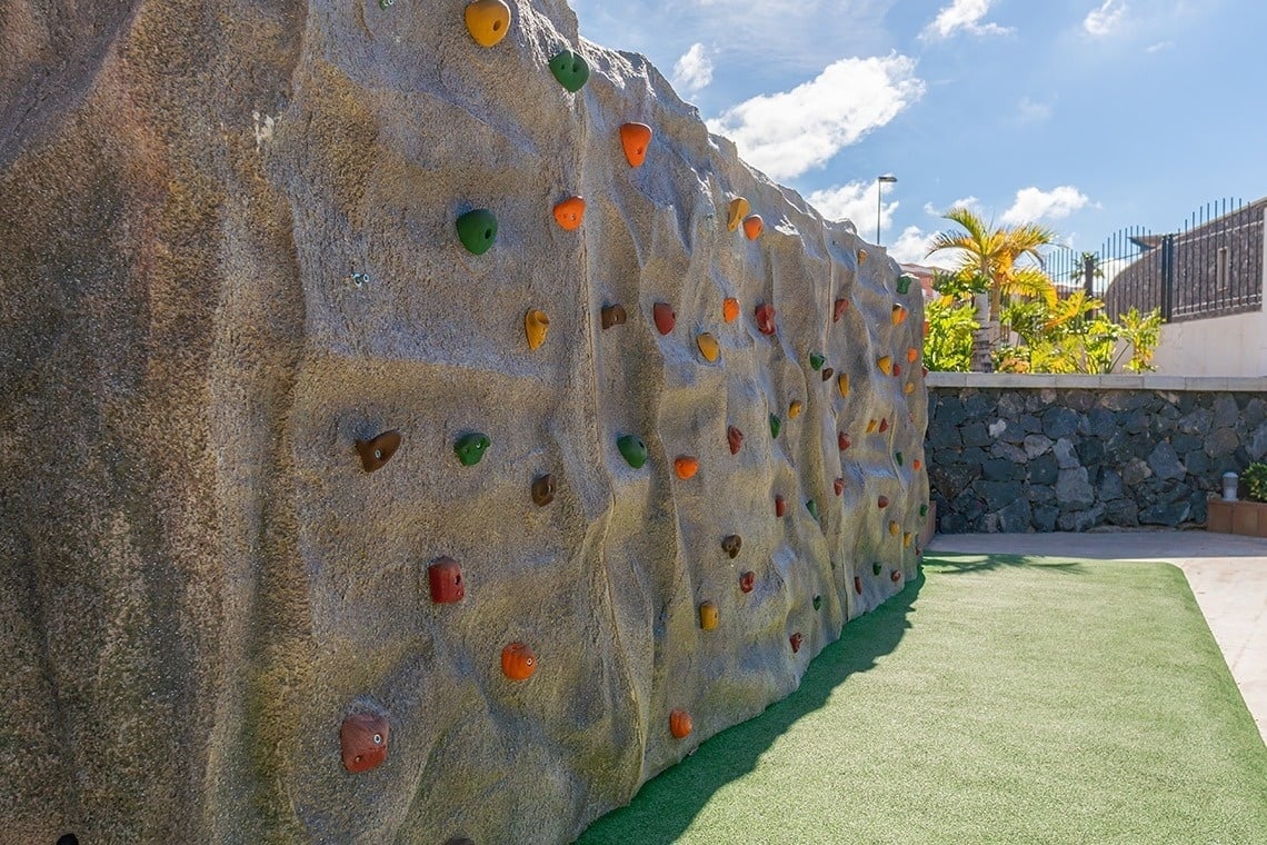 a climbing wall with a fence in the background