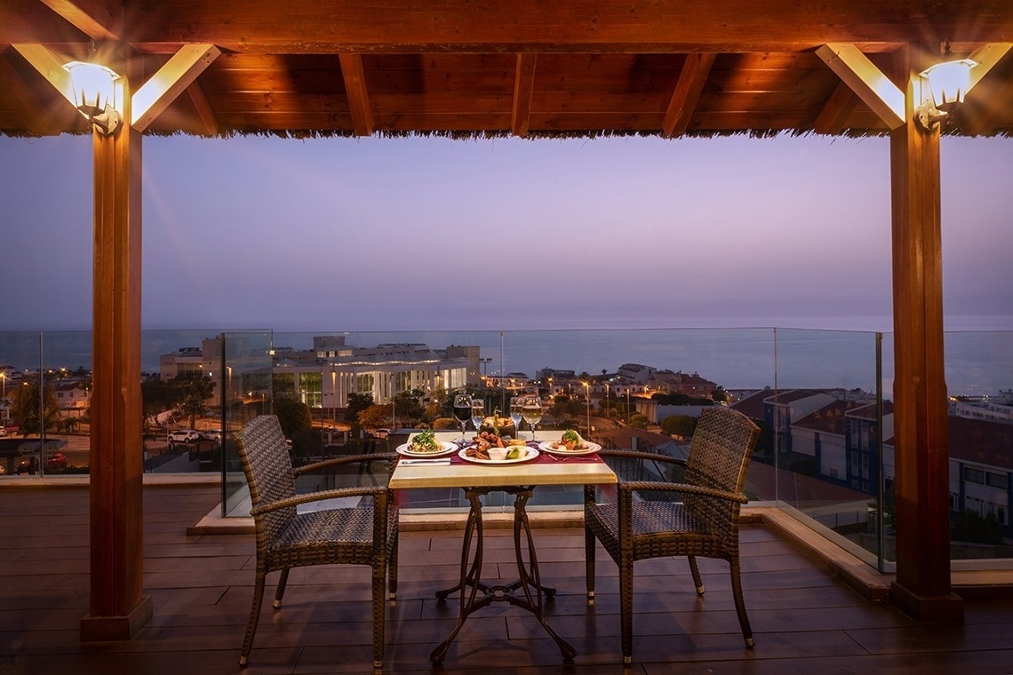 una mesa y sillas en una terraza con platos y copas de vino