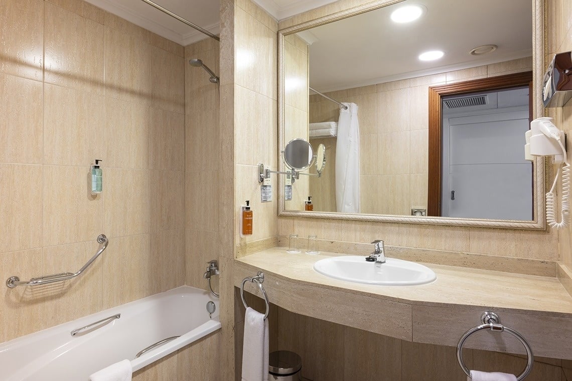 a bathroom with a bathtub sink and mirror