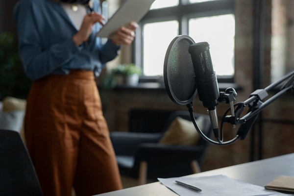 une femme tient une tablette à côté d' un microphone