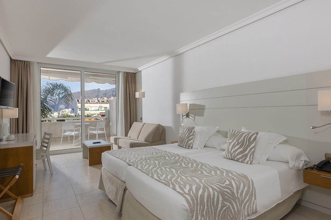 ein Hotelzimmer mit zwei Betten und einem Fernseher