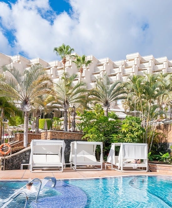 un grupo de personas se relaja en una piscina en un resort