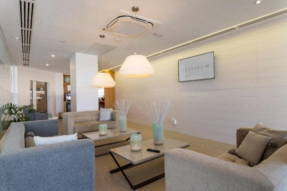 ein Wohnzimmer mit vielen Möbeln und einem silbernen Schild an der Wand