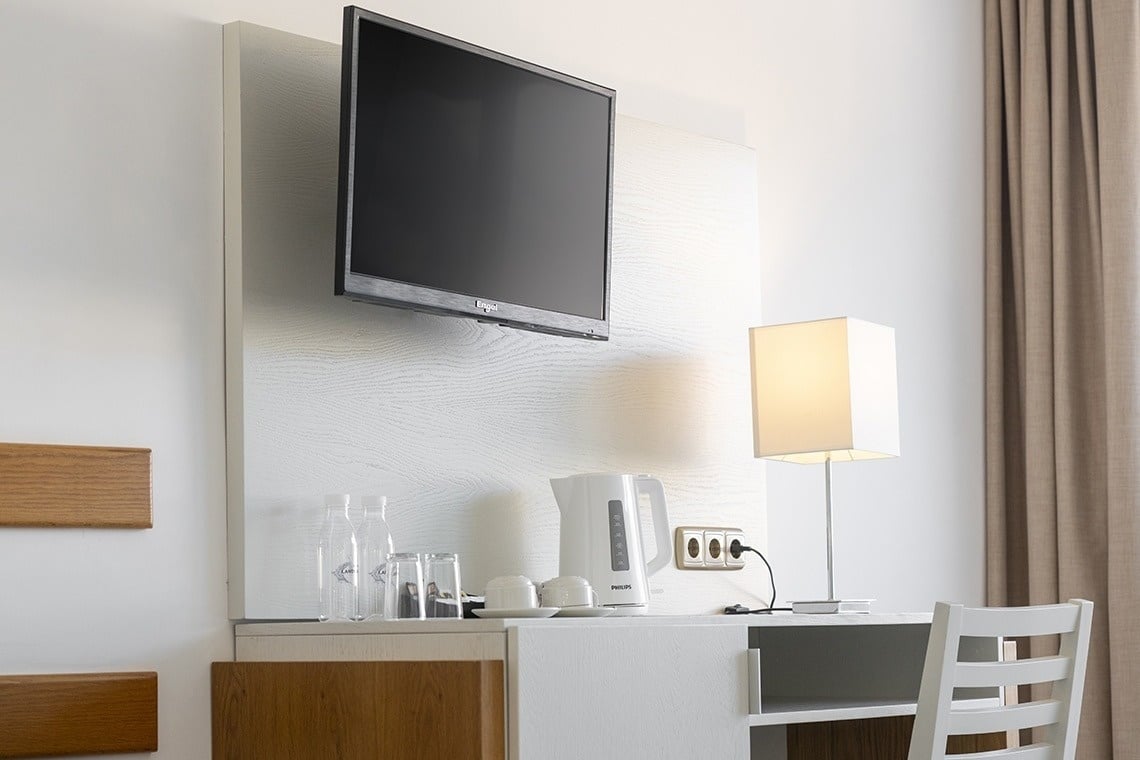 a flat screen tv is mounted on the wall above a desk