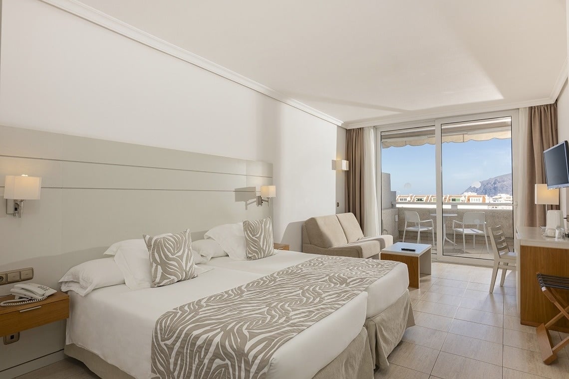 a hotel room with two beds and a balcony