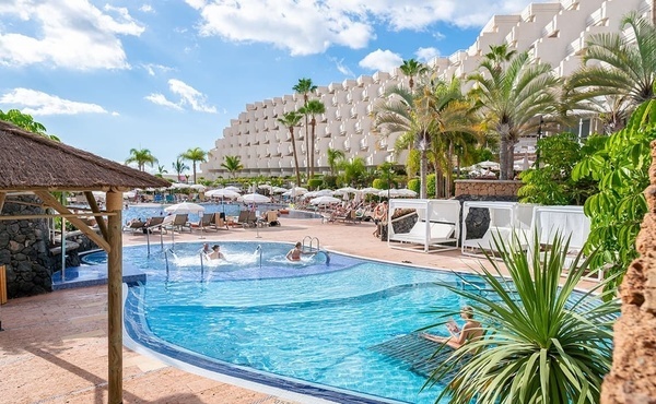 a large swimming pool with a hotel in the background