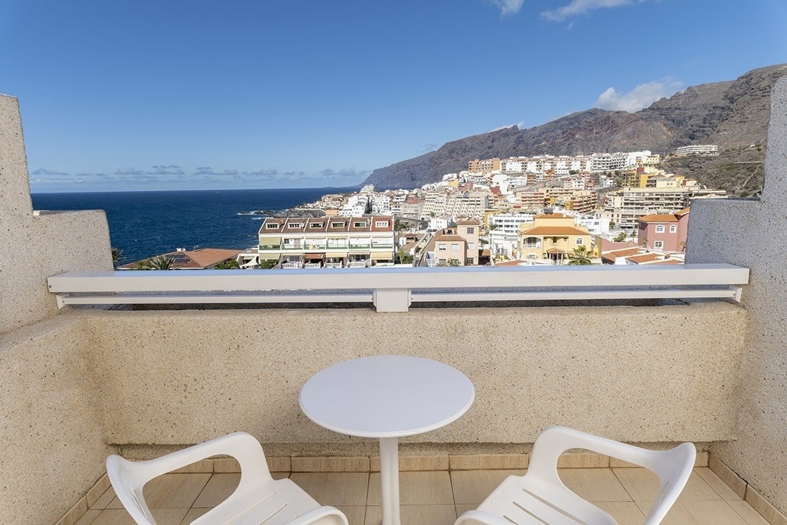 a balcony with a view of a city and the ocean
