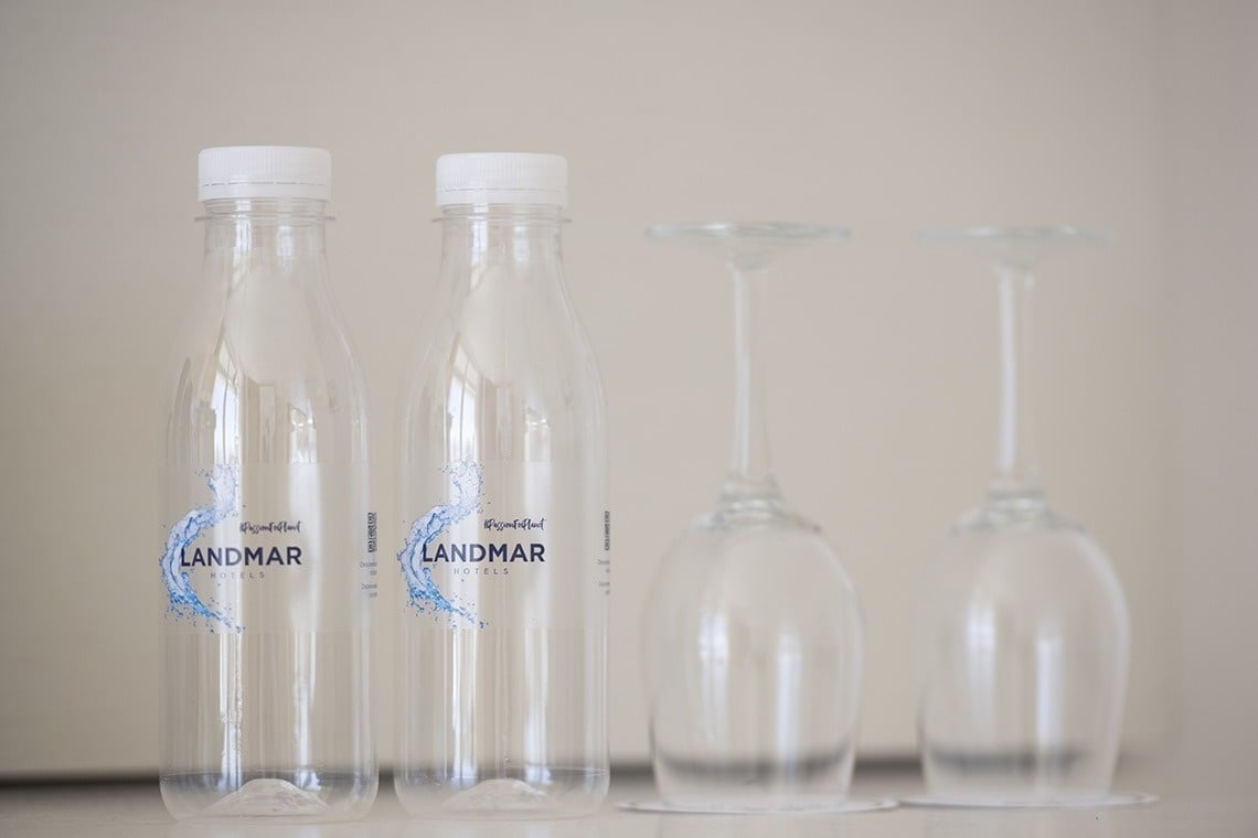 two bottles of landmar water sit next to two wine glasses