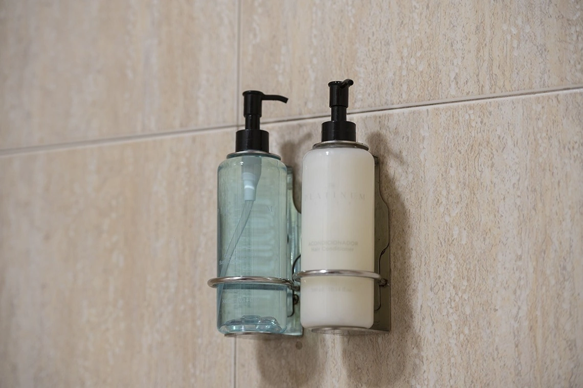 Distributeurs Landmar pour shampoing et après-shampoing dans une salle de bain d'hôtel.