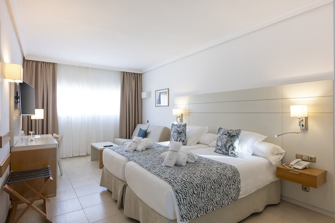 a hotel room with two beds and a chair