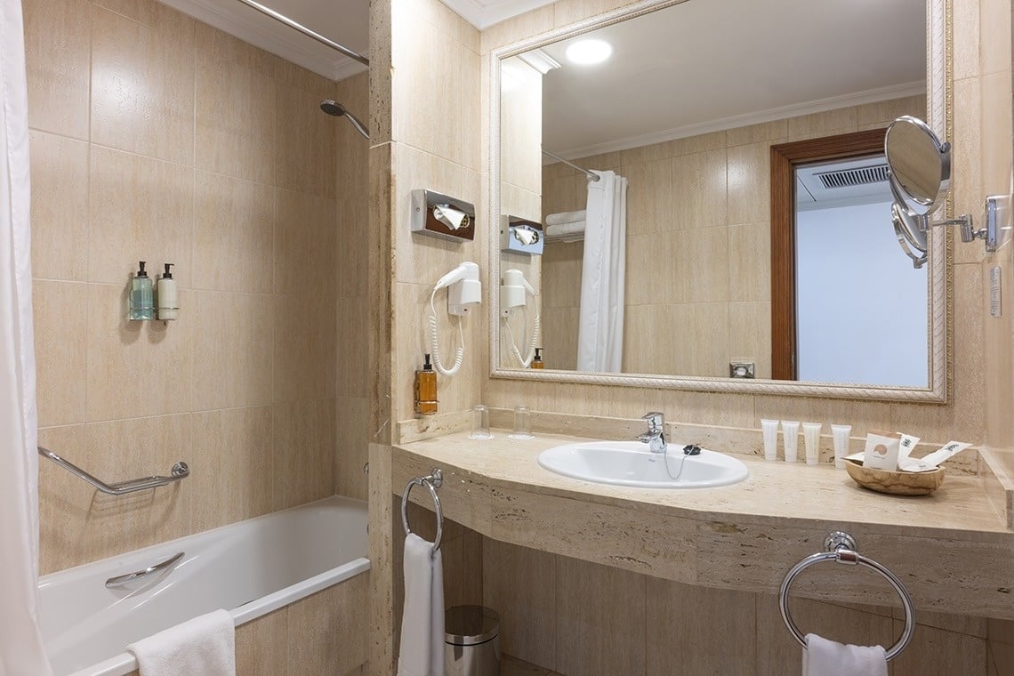 a bathroom with a bathtub sink and mirror