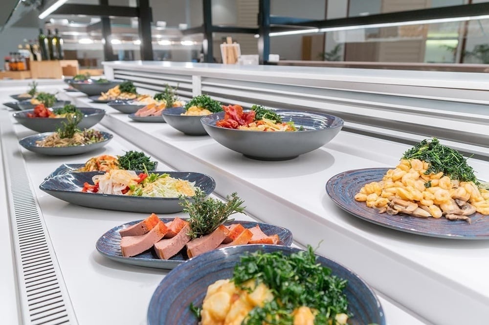 a buffet line with plates of food and bowls of food