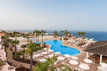 una pequeña piscina rodeada de sillas y sombrillas