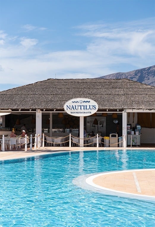 una pequeña piscina rodeada de sillas y sombrillas