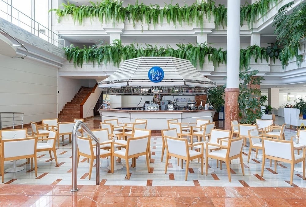 a lobby with tables and chairs and a kelly bar