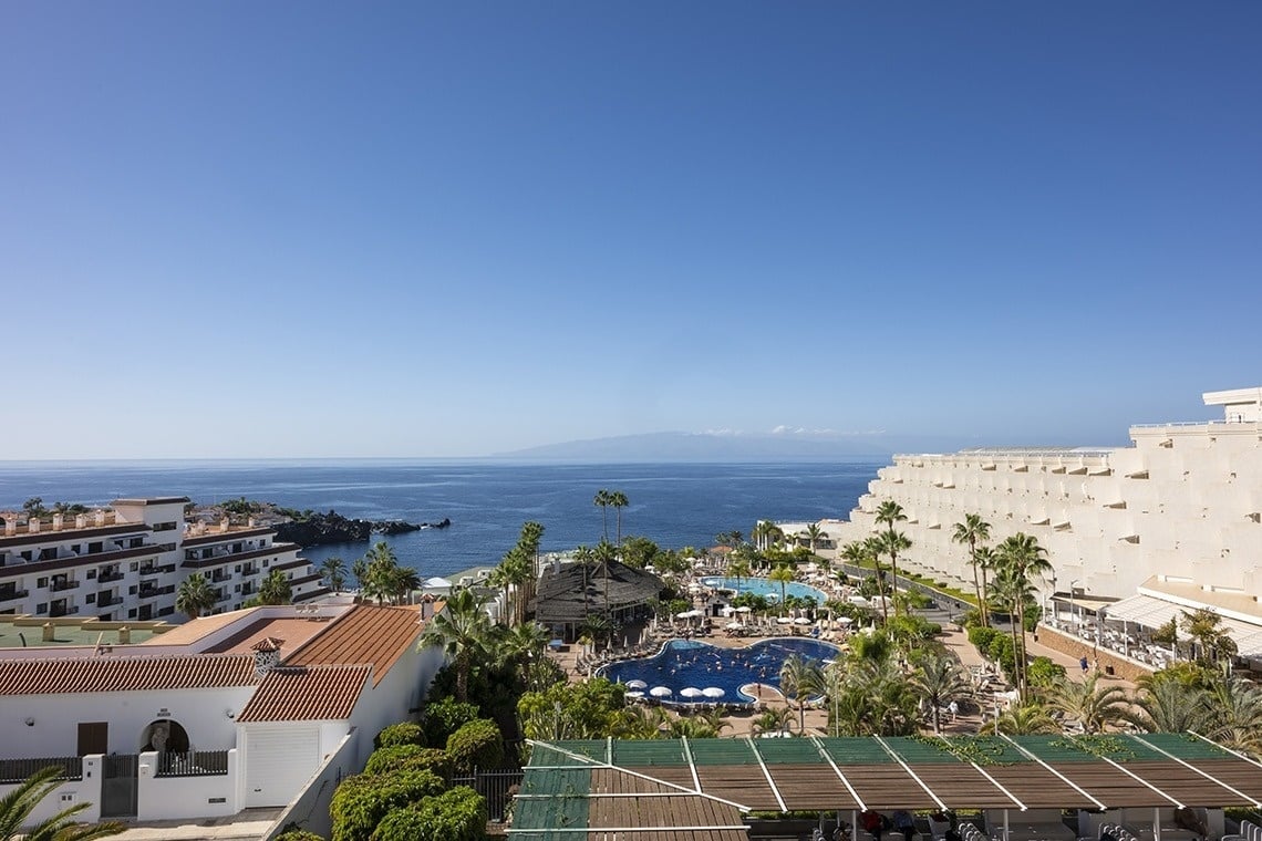 an aerial view of a resort with a large pool and palm trees
