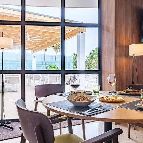 Modern indoor dining at ESTIVAL: Corporate Events, with terrace and palm views.