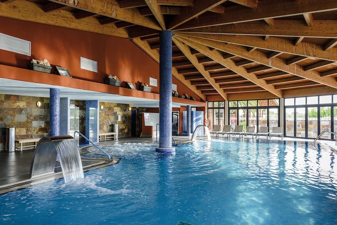 una piscina dentro de un spa con un techo de madera