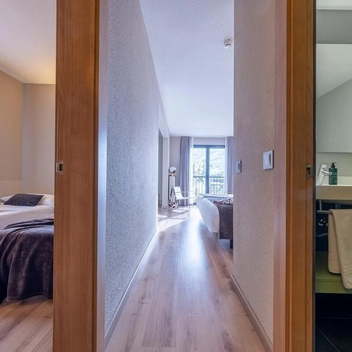 a bedroom with two beds and a bathroom with a sink