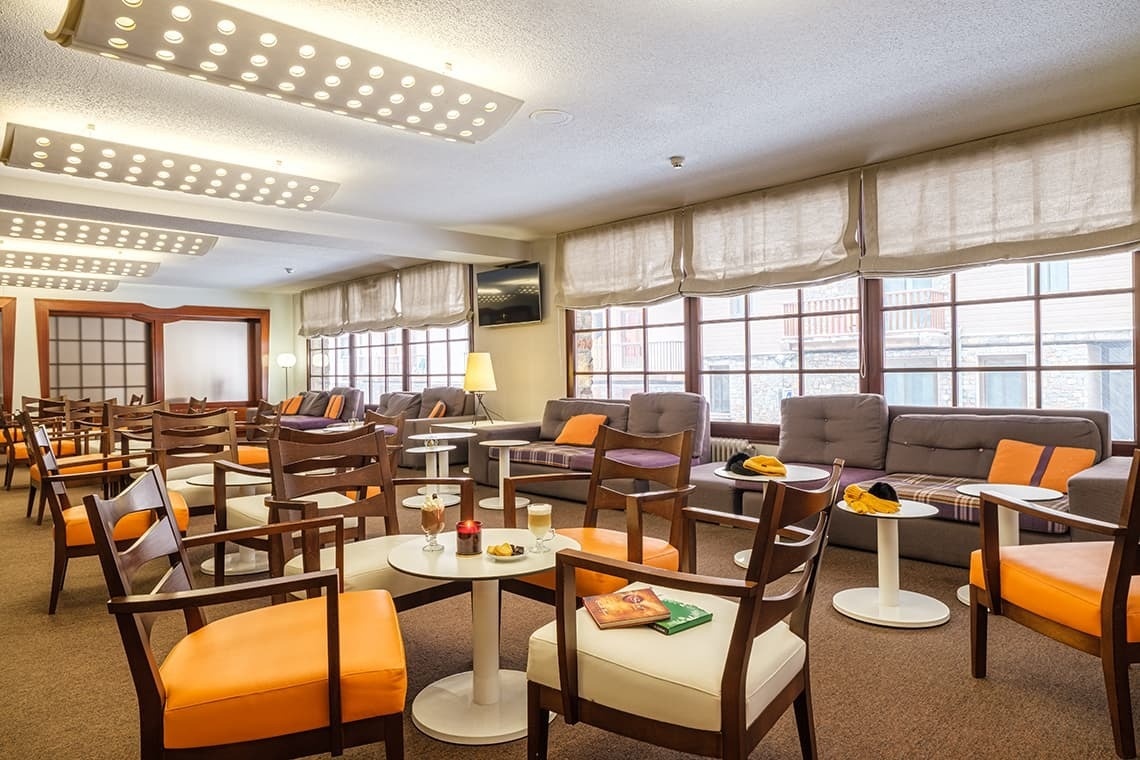 una sala de estar amb moltes cadires i unes taules