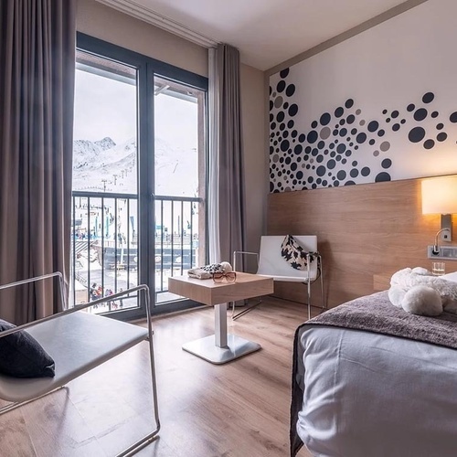 una habitació d' hotel amb una cama i una cadireta