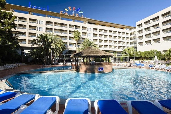 una gran piscina al davant d' un hotel