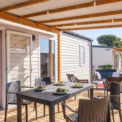 Terraza de Estival Vendrell Platja con mesa y sillas, ideal para disfrutar del aire libre.