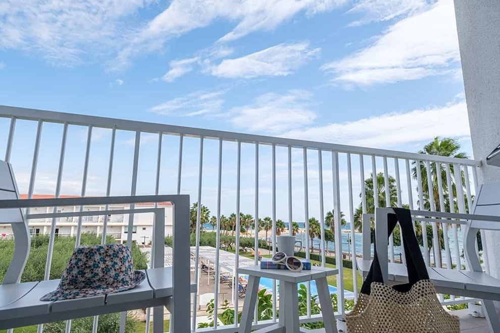 a hat sits on a chair on a balcony overlooking the ocean