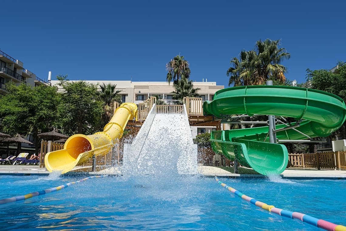 a water park with a yellow slide and a green slide