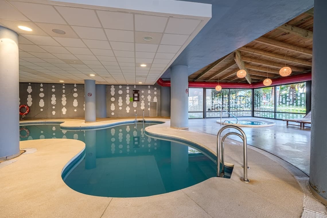 una piscina y un jacuzzi están dentro de un edificio