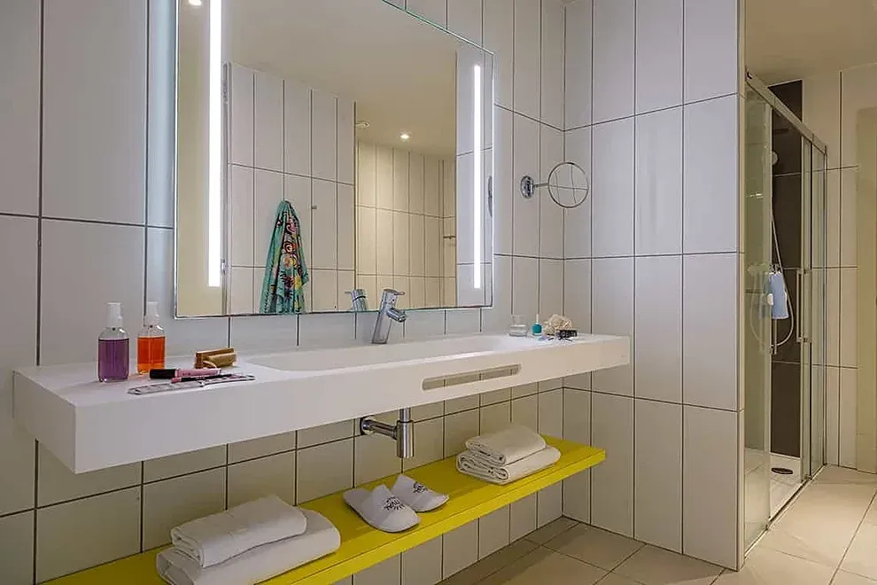 ESTIVAL: Corporativa: moderno baño con lavabo flotante y ducha acristalada.