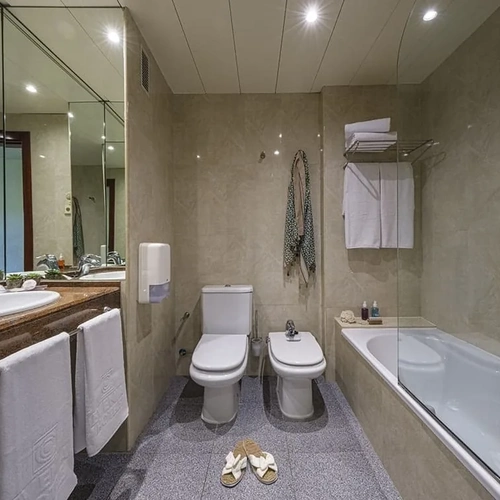Luxury bathroom with tub, toilet, and sink at ESTIVAL: Corporativa.