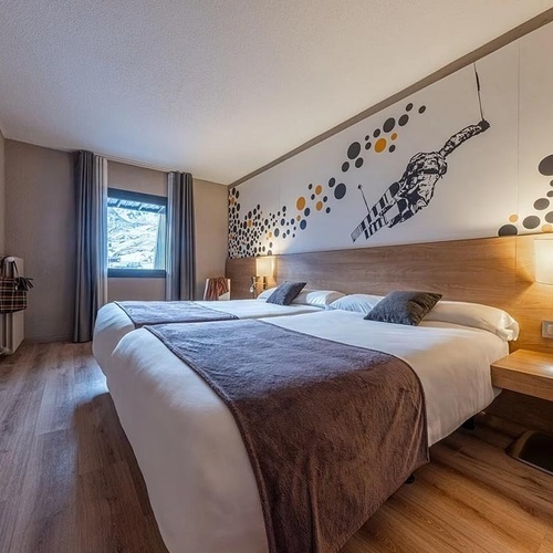 una habitació d' hotel amb dues camas i una televisió