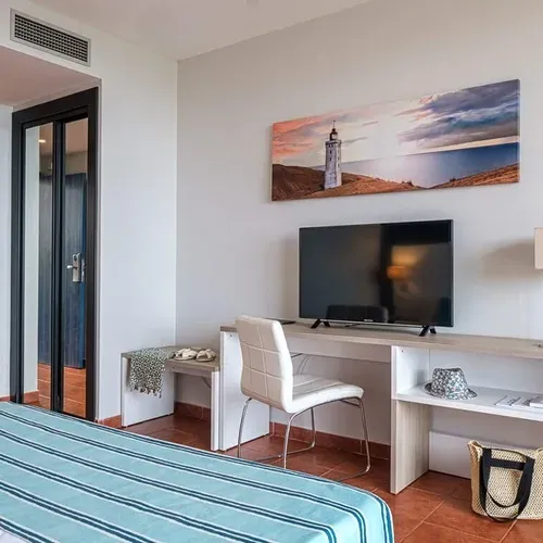 Estival Islantilla 4*: Modern hotel room with TV and mini-kitchen.