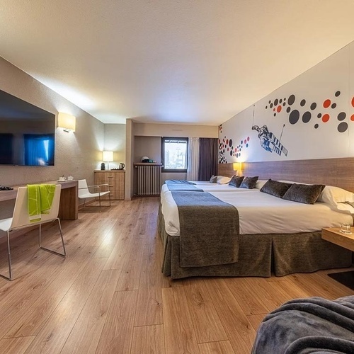 a hotel room with three beds and a flat screen tv