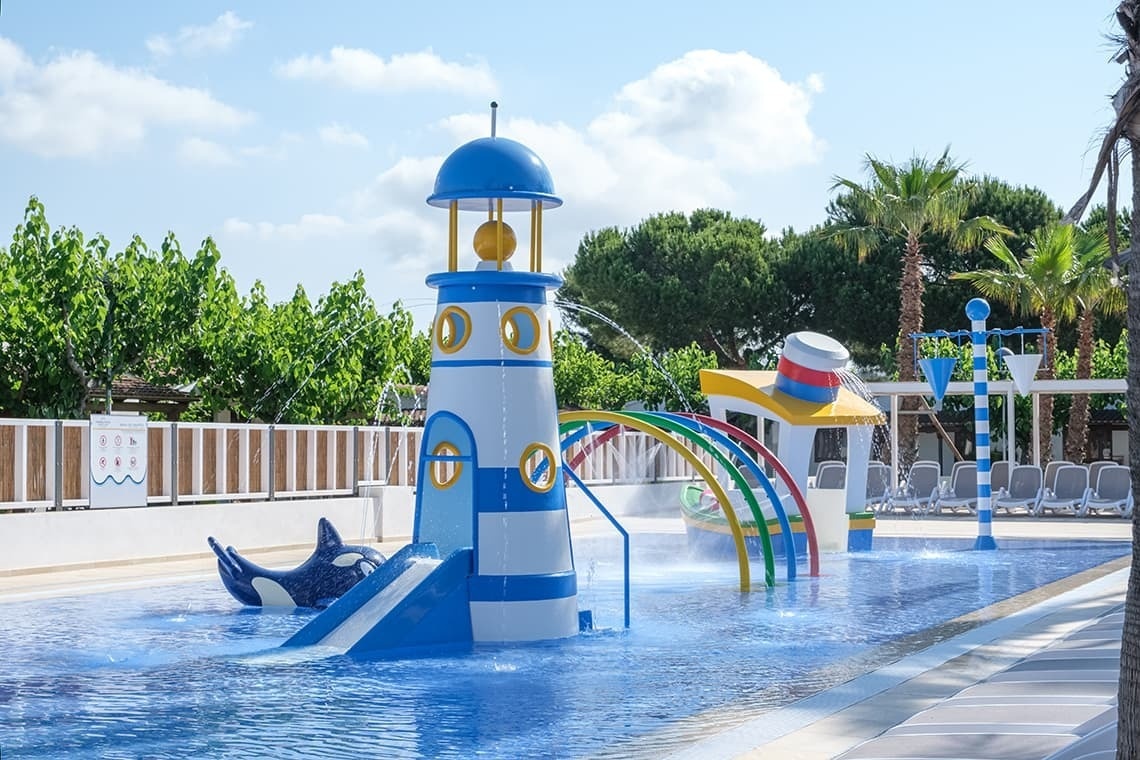 un parque acuático para niños con un faro y una ballena