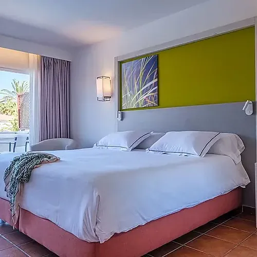ESTIVAL: Corporativa room with double bed, balcony, and modern art.