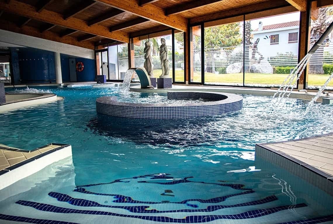una piscina con escaleras y una fuente en el medio