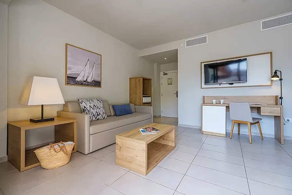 Salón moderno ESTIVAL: Corporativa con sofá, mesa y TV.