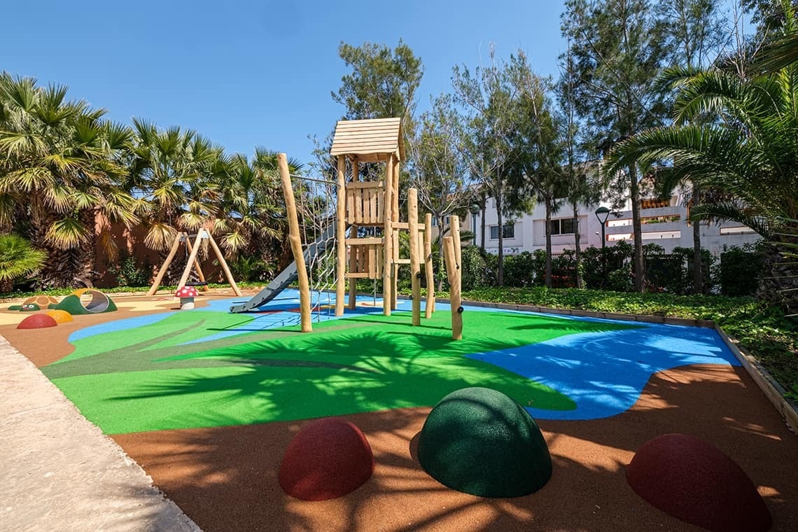 un parque infantil con un tobogán de madera y un columpio