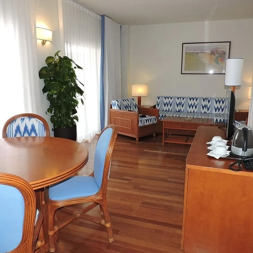 ESTIVAL: Corporate, living area with dining table and blue sofa.