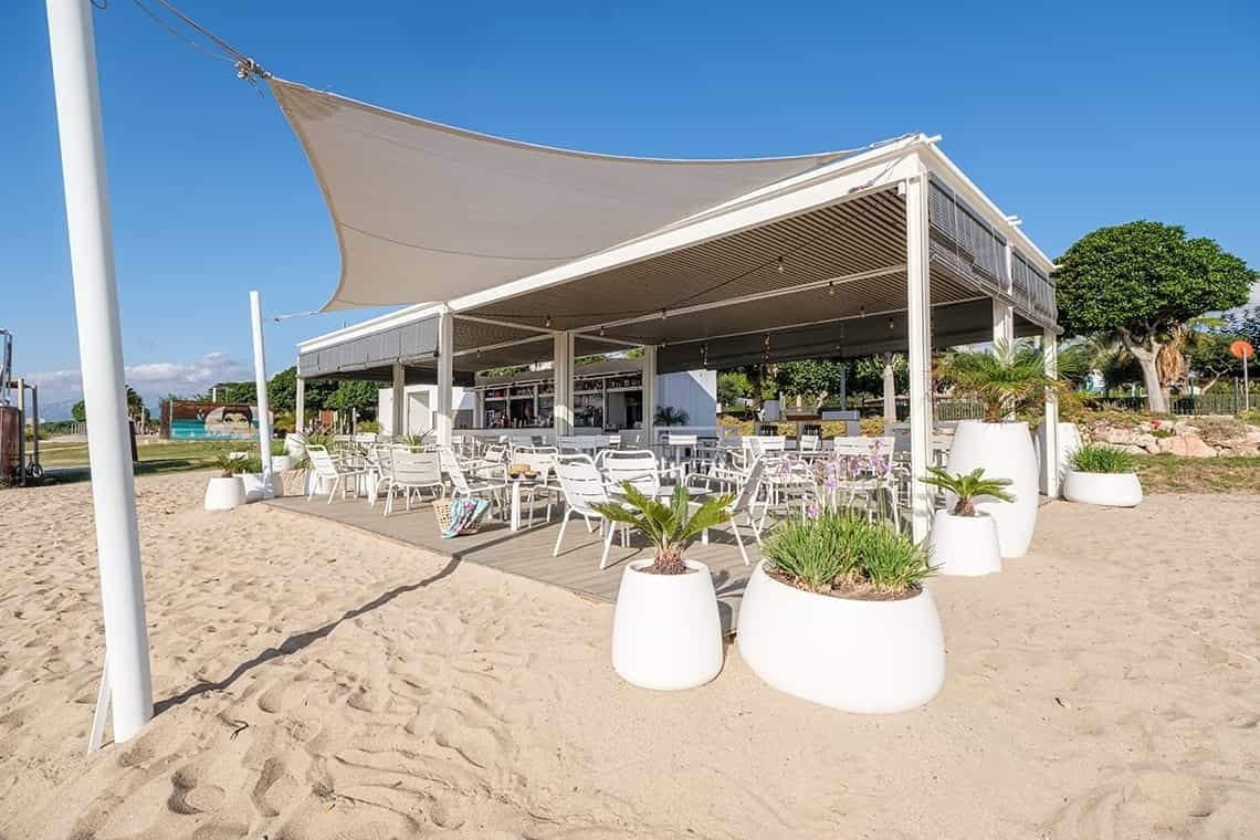 Estival Eldorado Resort: área de playa con mesas, sillas y toldo blanco para sombra. | Estival Group
